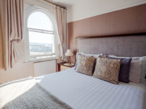 Spacious Elm Tree Hotel double bedroom with crisp white bedding and period windows